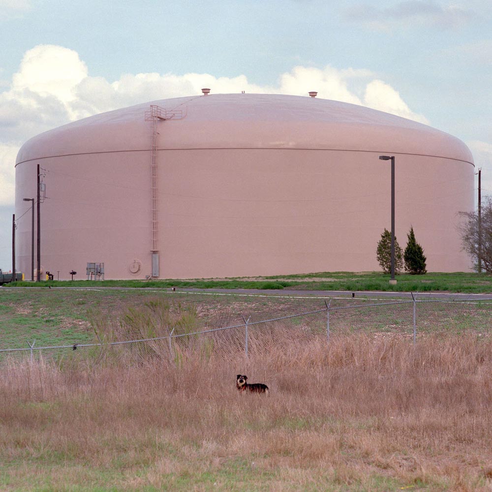 gases chemicals tanks storage refinery refineries ladders white dome building field sky blue green brown dog fence