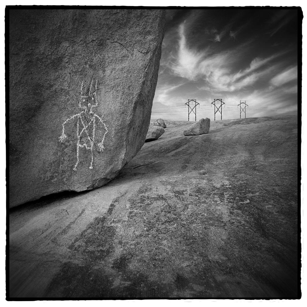 rocks ancient art power lines indian art black and white Modern ancient worlds timeless spiritual space of the shaman  Albuquerque, NM New Mexico gray grey rock boulder petroglyph sky bizarre book cover surrealism